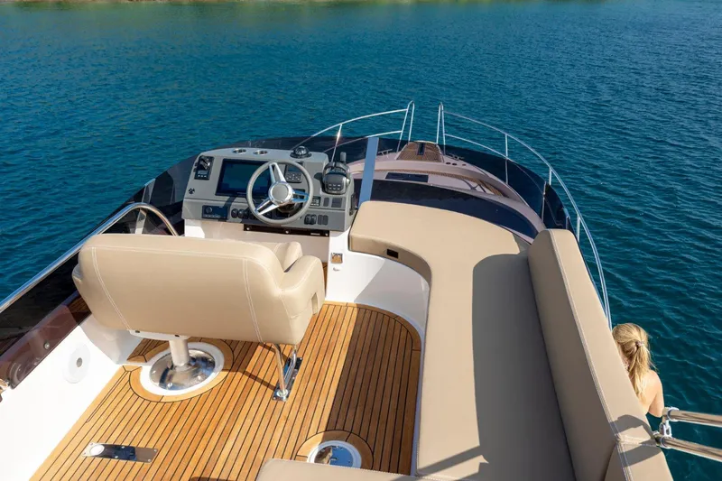  Yacht Photos Pics 2026 Nimbus 405 Flybridge yacht interior with steering wheel and seating on open water.