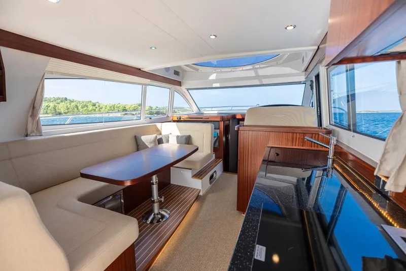  Yacht Photos Pics Luxurious interior of 2026 Nimbus 405 Flybridge yacht with elegant seating and panoramic windows.