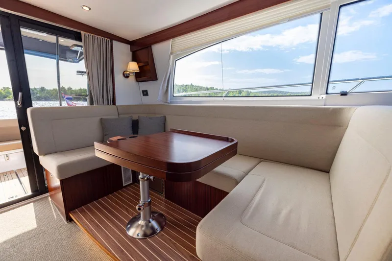  Yacht Photos Pics Luxurious interior of 2026 Nimbus 405 Flybridge yacht with elegant seating and wooden table.