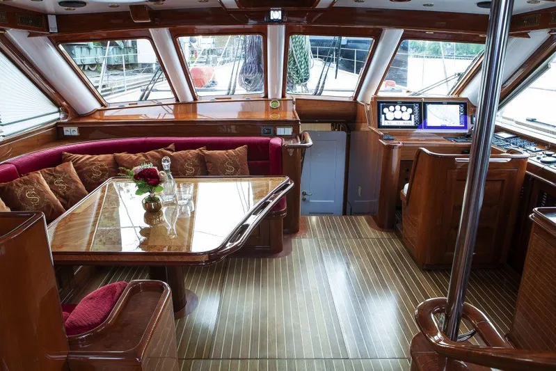 Selene Rouge Yacht Photos Pics Luxurious yacht interior with wood finish, dining area, and navigation equipment, Custom Line SMY 117, 2021.