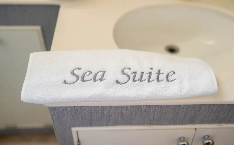 Sea Suite Yacht Photos Pics White towel embroidered with "Sea Suite" on a bathroom counter.