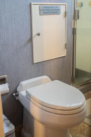 Sea Suite Yacht Photos Pics Restroom with toilet, wall cabinet, and shower in a 1974 Burger model 67.