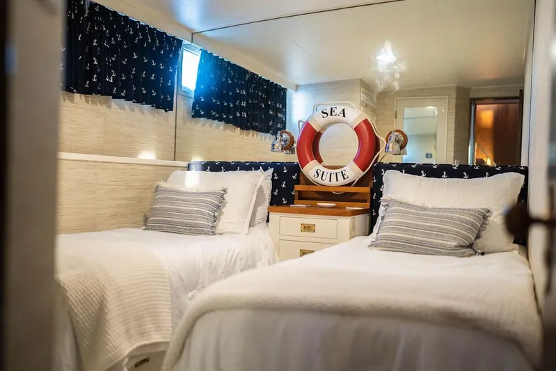 Sea Suite Yacht Photos Pics Cozy yacht cabin with twin beds, nautical decor, and "Sea Suite" lifebuoy.