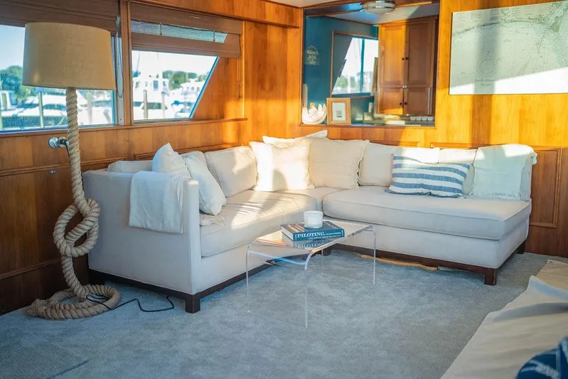 Sea Suite Yacht Photos Pics Luxurious yacht interior with cozy beige sofa, nautical decor, and sunlight streaming through windows.
