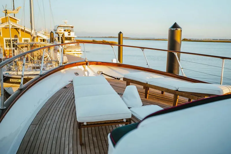Sea Suite Yacht Photos Pics Luxurious 1974 Burger 67 yacht deck with white seating, docked at serene marina.
