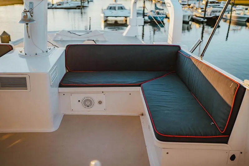 Sea Suite Yacht Photos Pics 1974 Burger 67 yacht seating area with marina view, featuring cushioned benches and nautical decor.