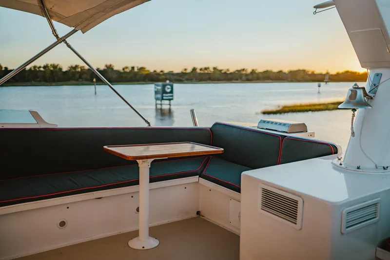 Sea Suite Yacht Photos Pics Luxurious seating area on a 1974 Burger 67 yacht at sunset by the water.