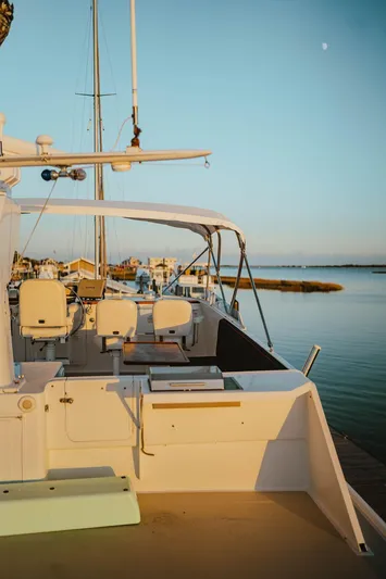 Sea Suite Yacht Photos Pics Vintage 1974 Burger yacht docked at sunset, featuring elegant seating and serene waterfront views.
