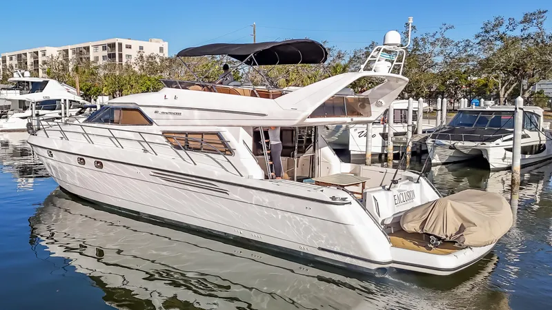  Yacht Photos Pics 1997 Viking Princess 60 Flybridge yacht docked in a marina, reflecting on calm water.