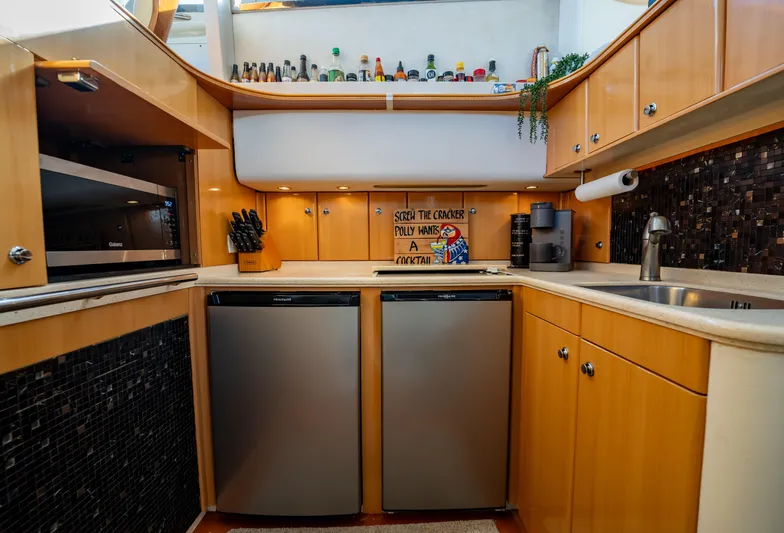  Yacht Photos Pics Modern kitchen in a 1997 Viking Princess 60 Flybridge yacht with sleek appliances and wood cabinetry.