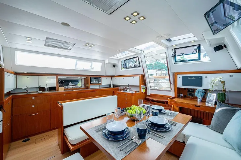 Icon Yacht Photos Pics Luxurious interior of 2014 Beneteau Sense 55 yacht with modern dining area and kitchen.