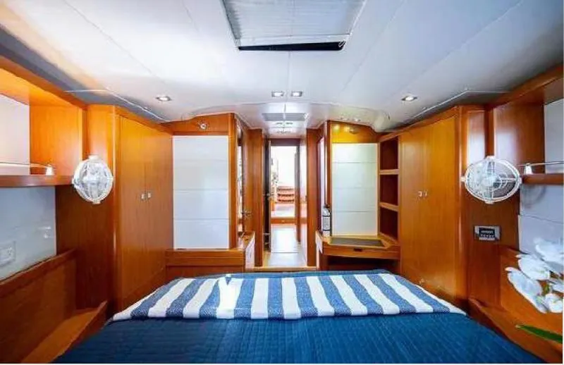 Icon Yacht Photos Pics Luxurious interior of 2014 Beneteau Sense 55 yacht with modern wood finish and cozy bedding.