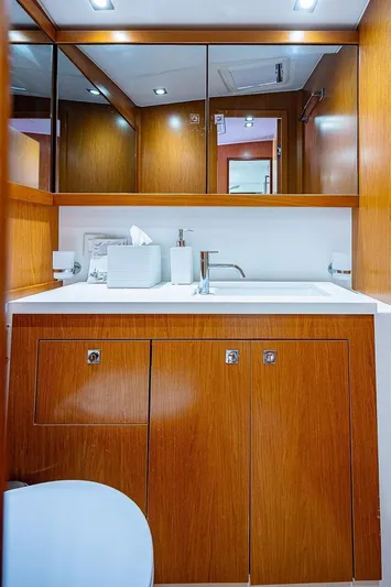 Icon Yacht Photos Pics 2014 Beneteau Sense 55 yacht bathroom with wooden cabinetry and modern fixtures.