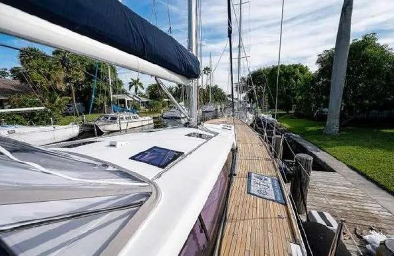 Icon Yacht Photos Pics 2014 Beneteau Sense 55 sailboat docked, showcasing sleek deck design and lush surroundings.