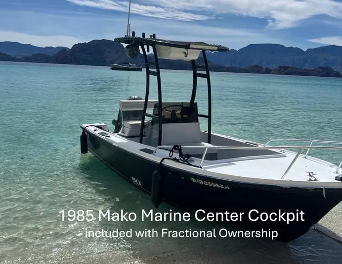 Icon Yacht Photos Pics A 1985 Mako Marine Center Cockpit boat on clear water with mountainous background.