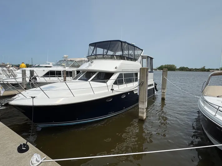 Y Knot Yacht Photos Pics 1997 Carver 405 Aft Cabin yacht docked at marina, side view.