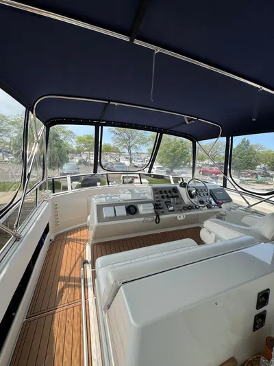 Y Knot Yacht Photos Pics 1997 Carver 405 Aft Cabin yacht interior with helm, seating, and canopy.