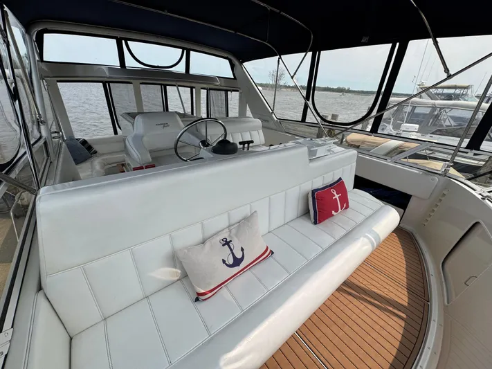 Y Knot Yacht Photos Pics 1997 Carver 405 Aft Cabin yacht interior with white seating and nautical-themed cushions.