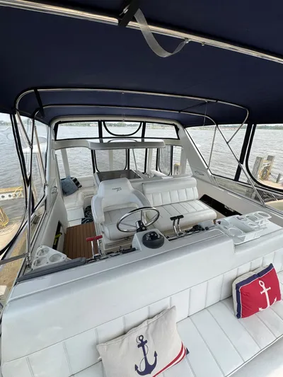 Y Knot Yacht Photos Pics 1997 Carver 405 Aft Cabin interior with white seating and nautical-themed cushions.