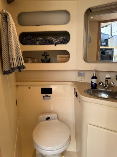 Y Knot Yacht Photos Pics 1997 Carver 405 Aft Cabin bathroom with toilet, sink, and shelves.