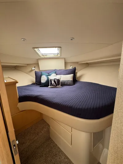 Y Knot Yacht Photos Pics 1997 Carver 405 Aft Cabin bedroom with navy bedding and decorative pillows.