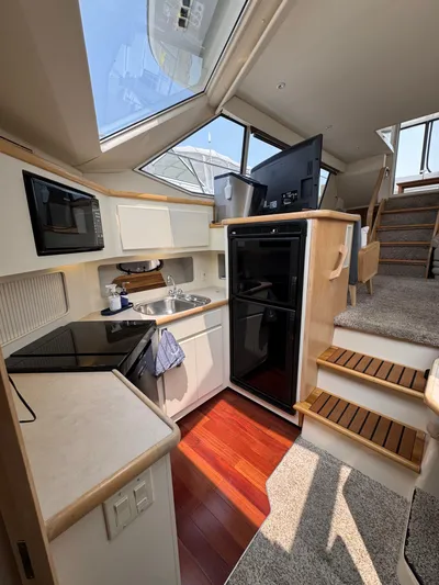 Y Knot Yacht Photos Pics 1997 Carver 405 Aft Cabin interior with modern kitchen and stairs.