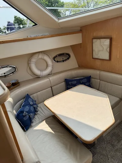 Y Knot Yacht Photos Pics 1997 Carver 405 Aft Cabin interior with beige seating, nautical decor, and skylight.