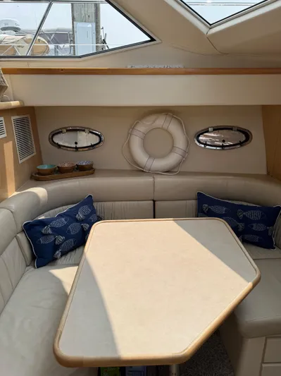 Y Knot Yacht Photos Pics 1997 Carver 405 Aft Cabin interior with dining area, nautical decor, and plush seating.
