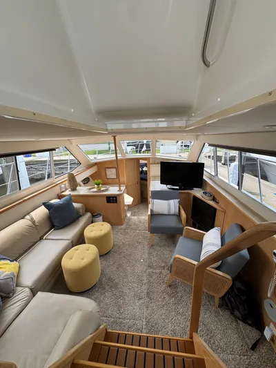 Y Knot Yacht Photos Pics 1997 Carver 405 Aft Cabin interior with cozy seating, TV, and modern decor.