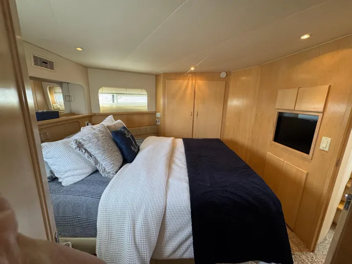 Y Knot Yacht Photos Pics Luxurious bedroom in 1997 Carver 405 Aft Cabin yacht with cozy bedding and modern decor.