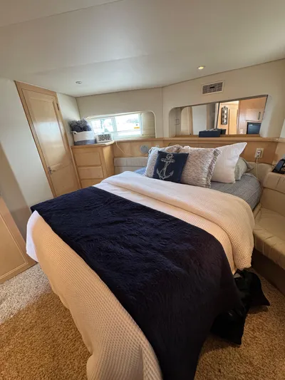 Y Knot Yacht Photos Pics 1997 Carver 405 Aft Cabin bedroom with cozy bedding and elegant decor.