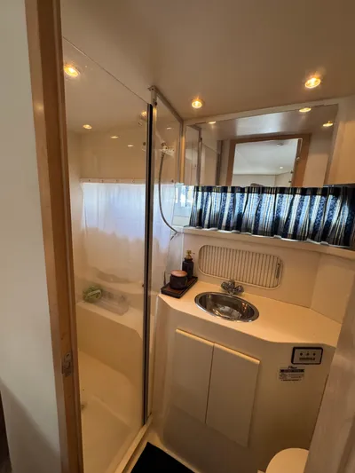Y Knot Yacht Photos Pics 1997 Carver 405 Aft Cabin bathroom with shower, sink, and mirror.