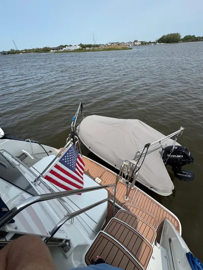 Y Knot Yacht Photos Pics 1997 Carver 405 Aft Cabin yacht with American flag, docked by calm waters.