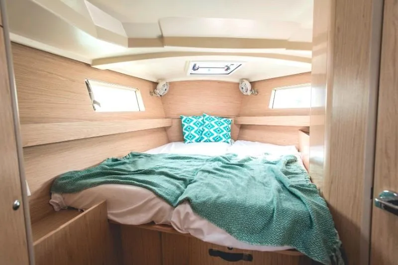  Yacht Photos Pics Cozy cabin interior of 2019 Beneteau Oceanis 41.1 yacht with bed and teal accents.