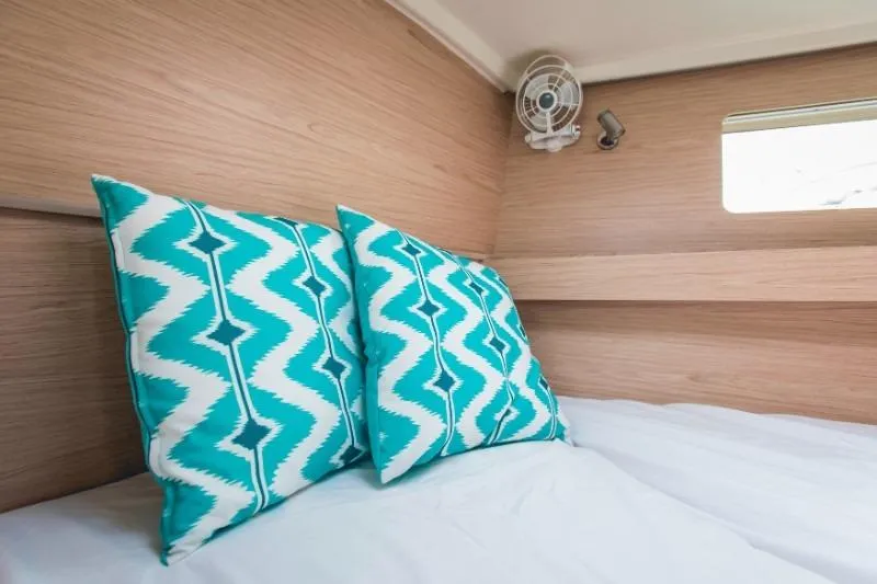  Yacht Photos Pics Cozy cabin interior of 2019 Beneteau Oceanis 41.1 with patterned pillows and wooden finish.