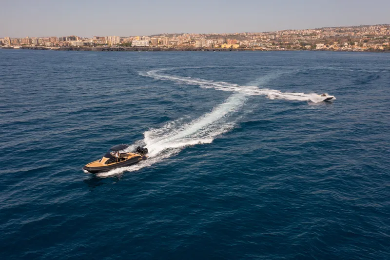  Yacht Photos Pics 2025 SPX RIB 38 Sport boat cruising on open sea near coastal city.