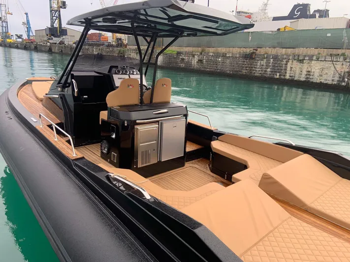  Yacht Photos Pics 2025 SPX RIB 38 Sport boat with tan seating and black exterior in a marina.