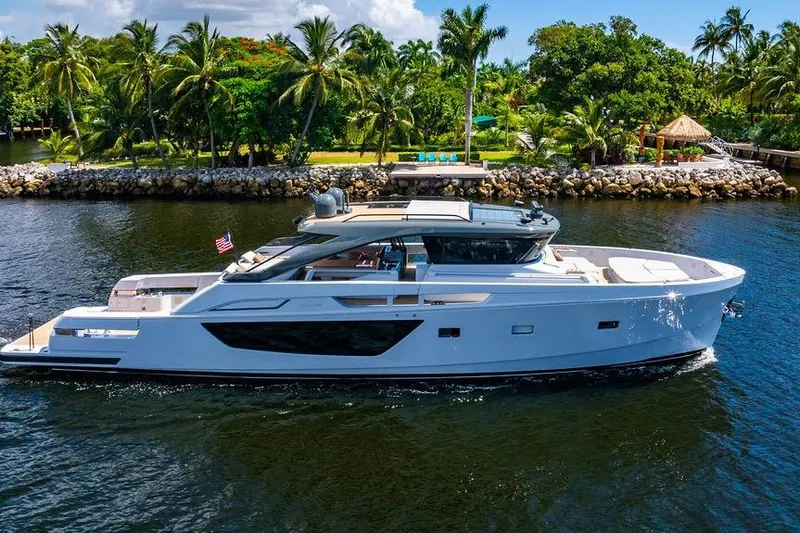 Snack Money Yacht Photos Pics 2023 Bluegame BG 72 yacht cruising near a tropical shoreline with palm trees.