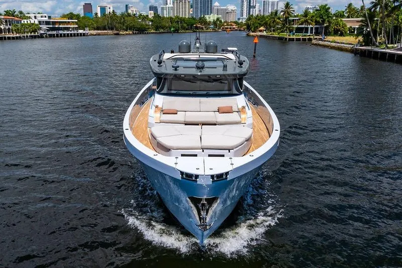 Snack Money Yacht Photos Pics 2023 Bluegame BG 72 yacht cruising on a scenic waterway with city skyline.
