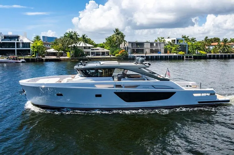 Snack Money Yacht Photos Pics 2023 Bluegame BG 72 yacht cruising on a sunny day, with waterfront homes in the background.