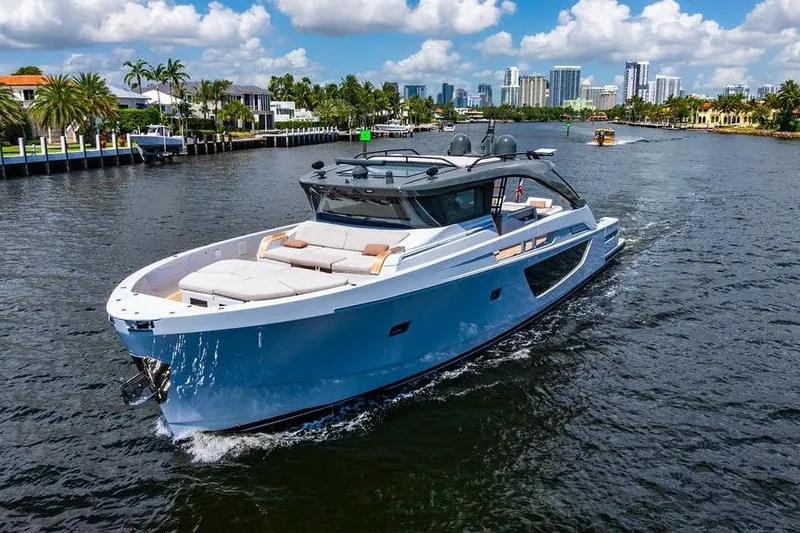 Snack Money Yacht Photos Pics 2023 Bluegame BG 72 yacht cruising on a scenic waterway with city skyline.