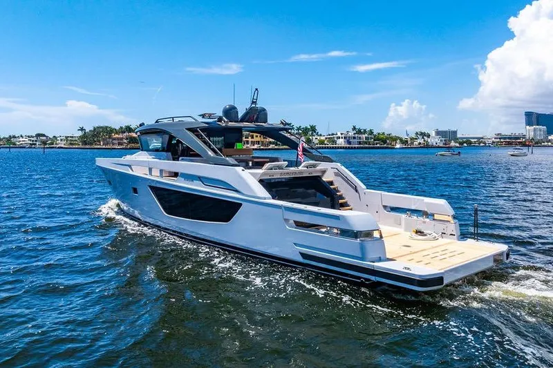 Snack Money Yacht Photos Pics 2023 Bluegame BG 72 yacht cruising on a sunny day in a coastal area.