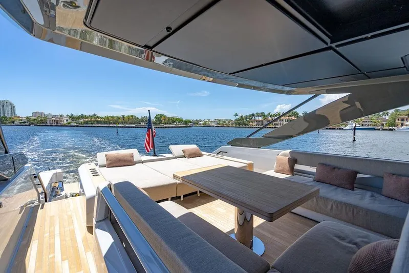 Snack Money Yacht Photos Pics Luxurious 2023 Bluegame BG 72 yacht deck with seating, table, and waterfront view.