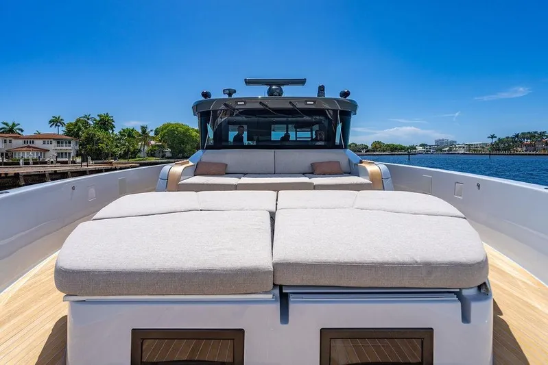 Snack Money Yacht Photos Pics Luxurious 2023 Bluegame BG 72 yacht with spacious sunbathing deck, cruising on a sunny day.