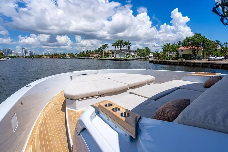 Snack Money Yacht Photos Pics Luxurious 2023 Bluegame BG 72 yacht with spacious deck and scenic waterfront view.