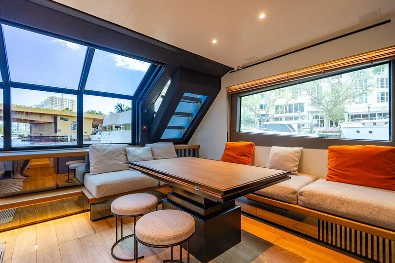Snack Money Yacht Photos Pics Luxurious interior of 2023 Bluegame BG 72 yacht with modern seating and large windows.
