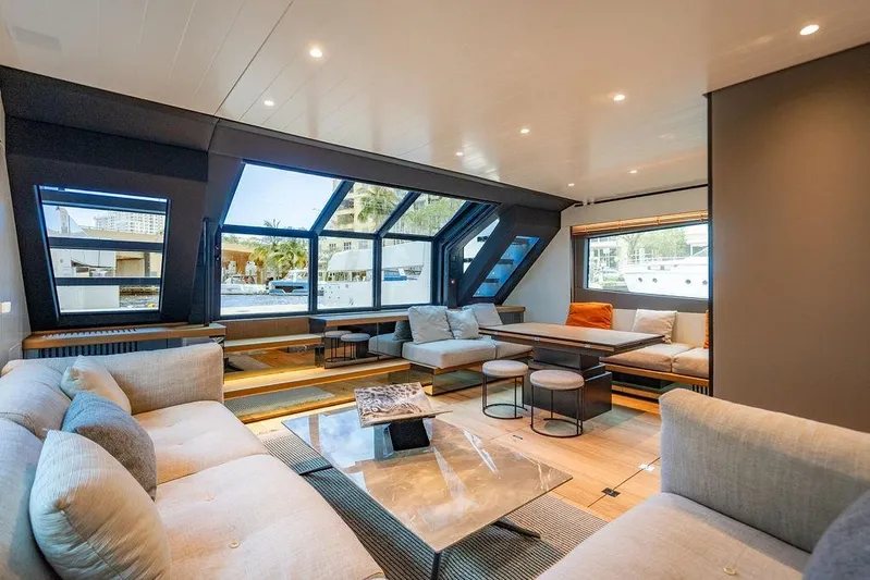 Snack Money Yacht Photos Pics Luxurious interior of 2023 Bluegame BG 72 yacht with modern seating and large windows.
