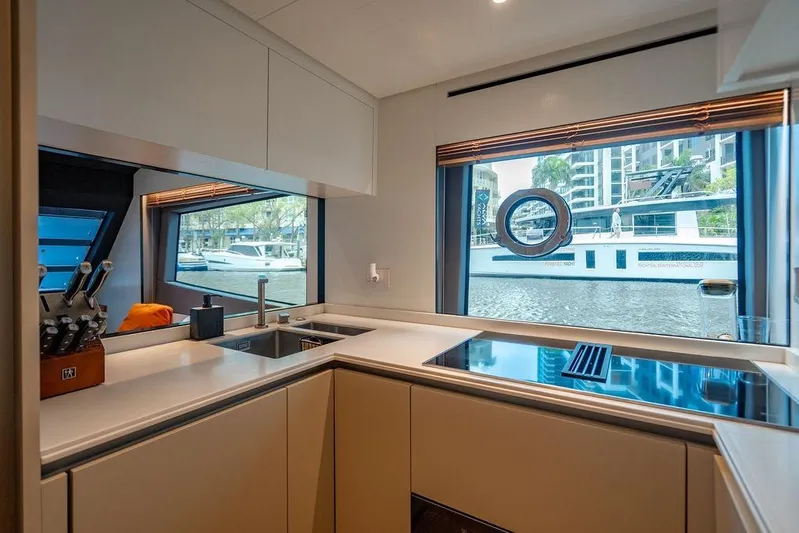 Snack Money Yacht Photos Pics Modern kitchen interior on 2023 Bluegame BG 72 yacht with large windows and sleek design.