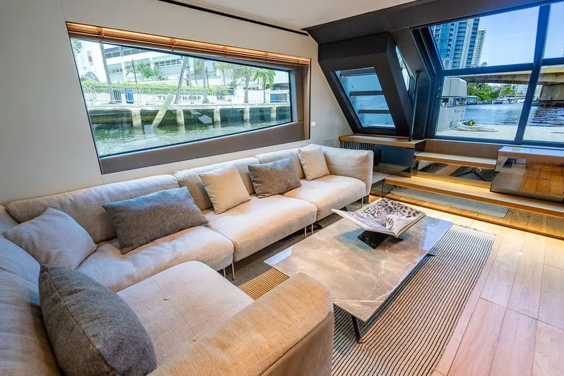 Snack Money Yacht Photos Pics Luxurious interior of 2023 Bluegame BG 72 yacht with modern seating and large windows.