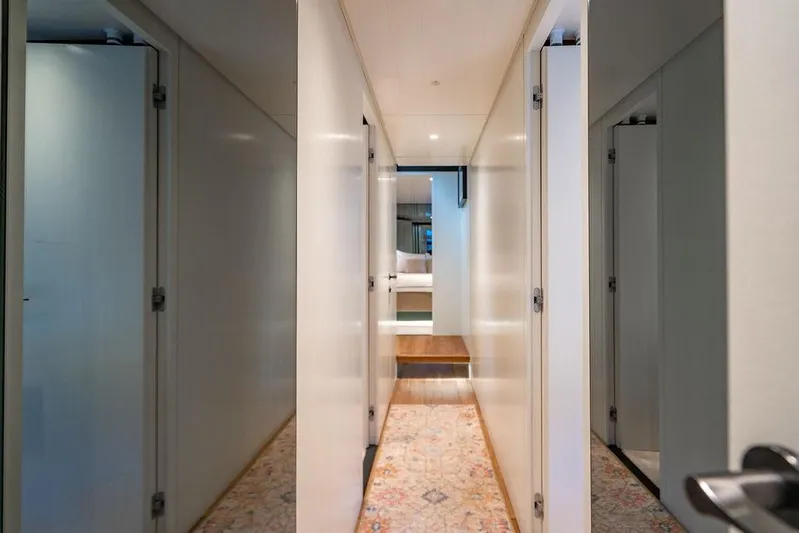 Snack Money Yacht Photos Pics Interior hallway of 2023 Bluegame BG 72 yacht, featuring sleek white walls and modern design.